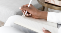 Woman hand writing notes in notebook