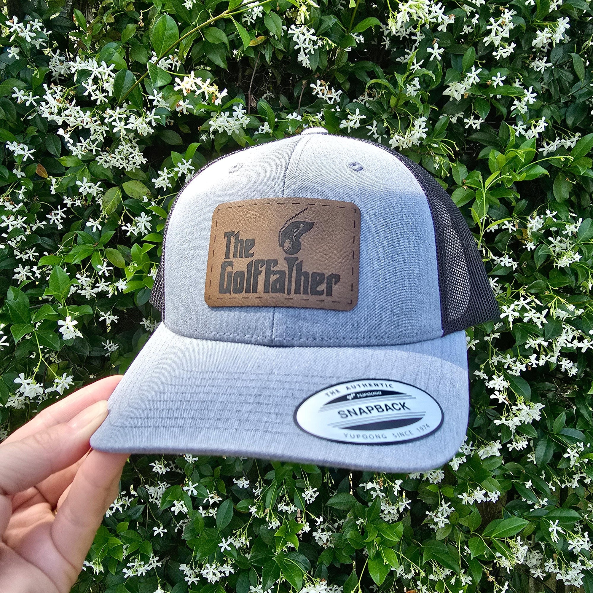 heather and black snapback trucker hat with brown leather patch engraved golf father.